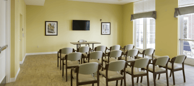 Interior view of a meeting room with chairs and a TV