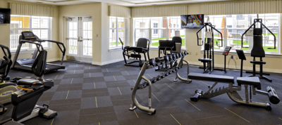 A modern fitness center with equipment and natural light