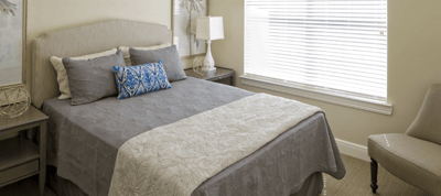 Cozy resident bedroom with a made bed and natural light