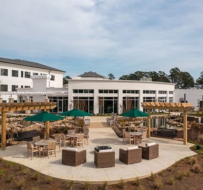 Outdoor seating area with shaded tables and landscaping