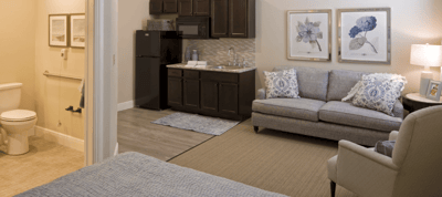 A cozy resident room with a kitchenette and living area