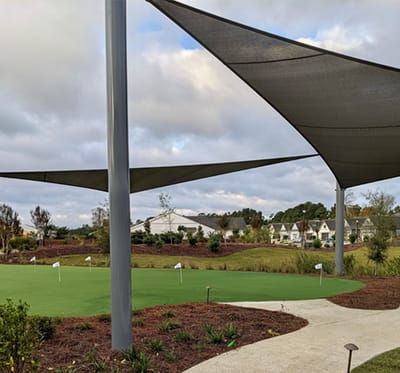 Outdoor shaded area with green space and seating