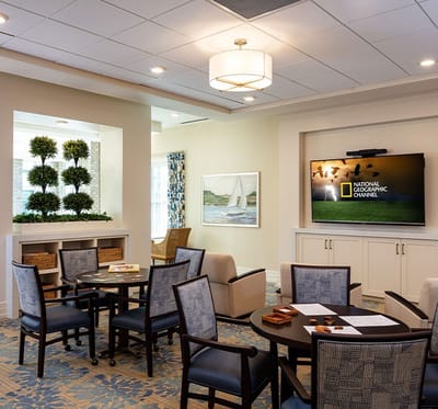 Common area with seating and TV in a senior living facility