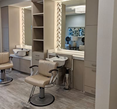 A modern salon area with styling chairs and mirrors