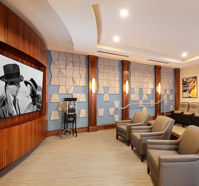 A modern common area with comfortable seating and a large screen