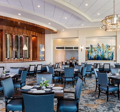 Elegant dining room with blue chairs and decorative wall