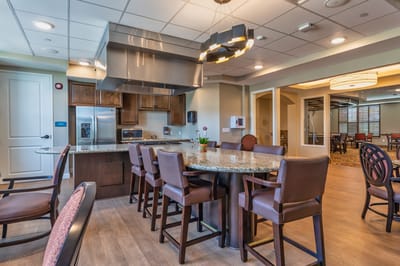Modern common area with kitchen and seating in a senior living facility