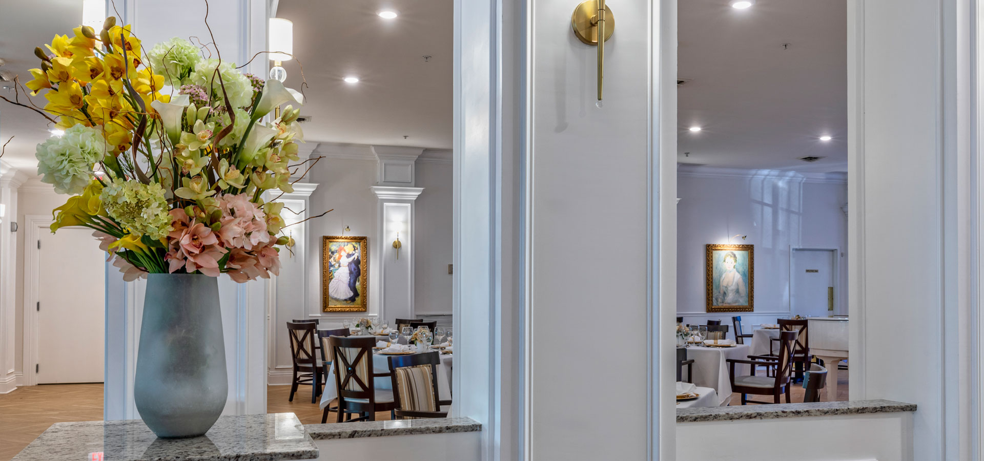 Bright dining area with floral arrangement and artwork