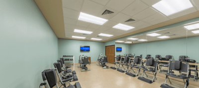 A fitness room with exercise equipment and mirrors