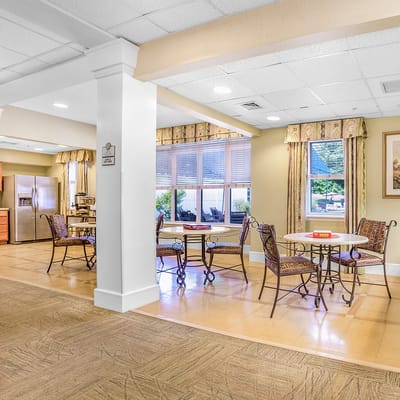 Bright common area with tables and chairs near windows