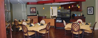 Dining area set up for a meal with tables and chairs