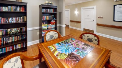Interior view of a common area with bookshelves and a table