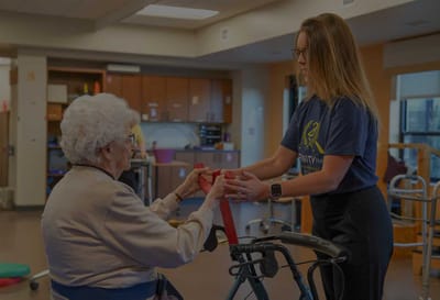 Resident receiving assistance with therapy activities