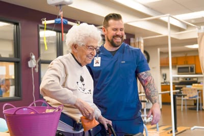Caregiver assisting a senior resident in an activity room