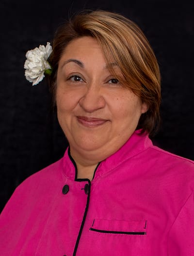 Care staff member smiling with a flower in her hair.