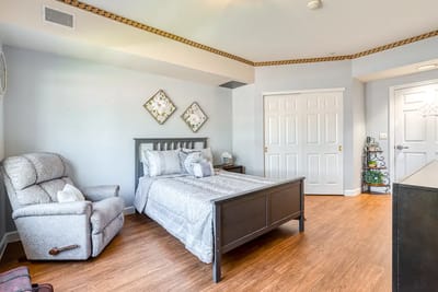 Well-furnished private resident room with bed and chair