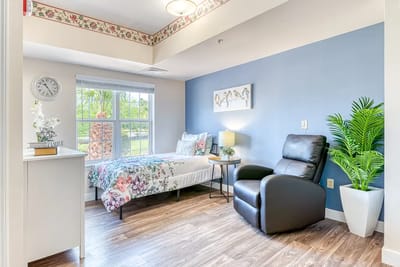 Cozy resident room with floral bedding and recliner