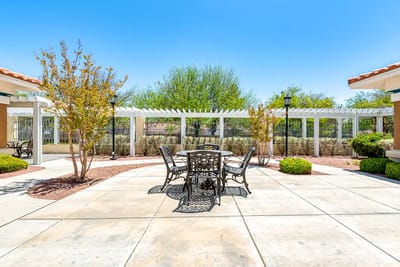 Outdoor seating area with tables and greenery