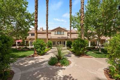 Exterior view of a senior living facility with palm trees