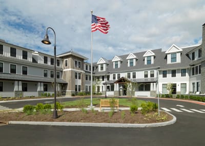 Exterior view of the assisted living facility with flag