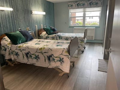 A shared resident room with two beds and floral decor