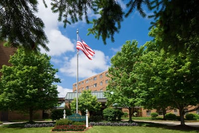 Exterior view of the facility with trees and an American flag