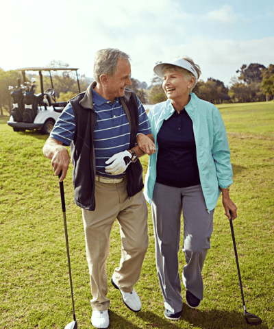 Two seniors enjoying a walk on the golf course