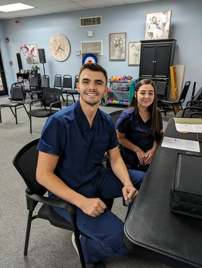Two staff members smiling in a common area