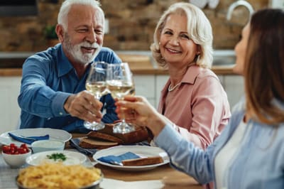 Residents toasting with glasses during a meal