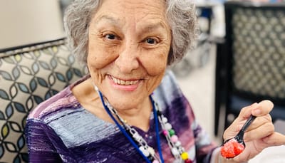 Resident enjoying dessert with a big smile