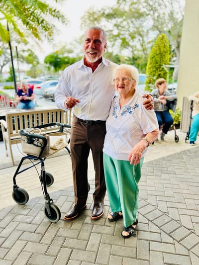 Resident and staff member sharing a joyful moment outdoors