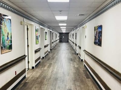 A well-lit interior hallway with artwork on the walls