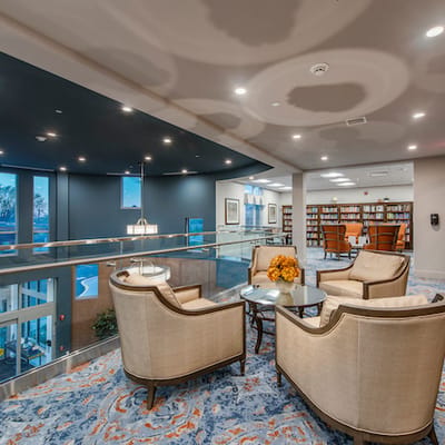 Bright common area with comfortable seating and a library.