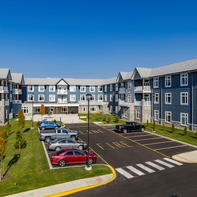 Exterior view of Meadowcrest Middletown with cars and lawn.