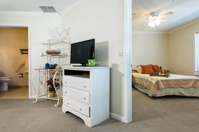 Cozy interior of a resident's room with a TV and bed.