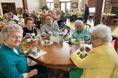 Residents enjoying meals and socializing in the dining room.