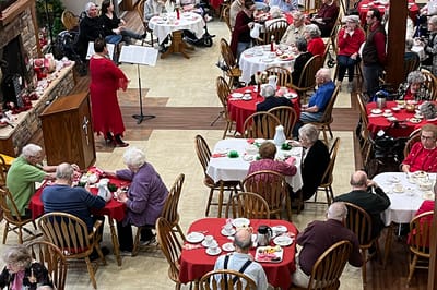 Residents enjoying a meal and entertainment in the dining room.