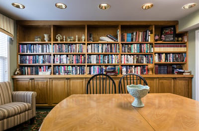 Cozy common area with bookshelves and dining table.