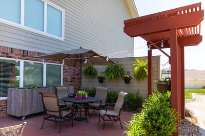 Outdoor seating area with plants and umbrellas.