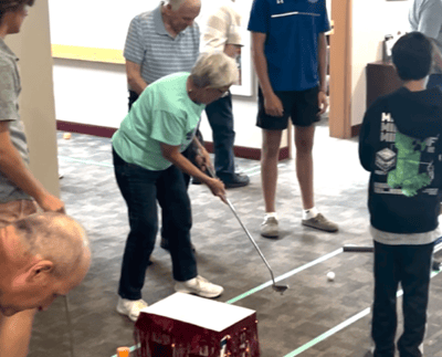 Residents involved in an indoor mini-golf activity.