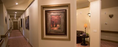 Elegant corridor with artwork and soft lighting.