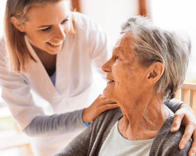 A caregiver smiling with an elderly resident.