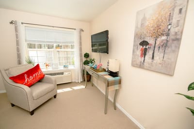 Cozy room with comfortable furnishings and artwork.