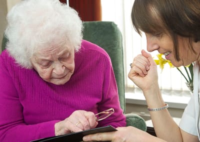Senior resident and staff member engaged in conversation.