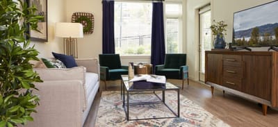 Cozy sitting area with green chairs and natural light.