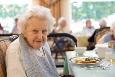 Resident enjoying lunch in a dining area.