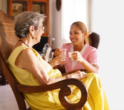 Caregiver and resident sharing a drink