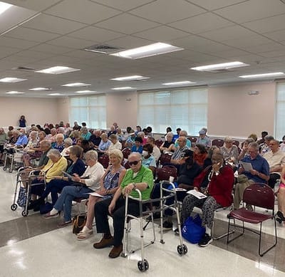 A large group of seniors sitting in a common area.