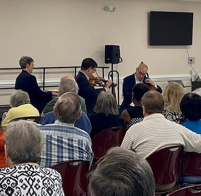 Residents enjoying a musical performance in a common area.