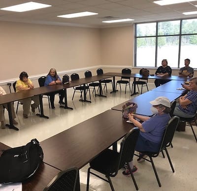 Group of people seated in a meeting room.